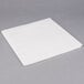 A white tissue / poly table cover on a gray surface.