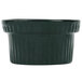 A hunter green cast aluminum souffle bowl with white specks and ridges.