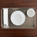A rectangular desert tan Cambro tray with a white plate, bowl, and cup on it.