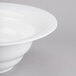 A Tablecraft white cast aluminum salad bowl with a wide rim.