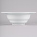 A white Tablecraft cast aluminum salad bowl with a wide white rim on a white surface.