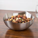 An American Metalcraft satin stainless steel bowl of mixed nuts on a table.