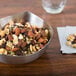 An American Metalcraft stainless steel bowl filled with mixed nuts and seeds on a table.