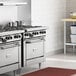 A professional kitchen with a Garland 6 burner range and oven.