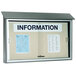 An Aarco light gray outdoor locking plastic lumber message center with a bulletin board inside with a sign on it.