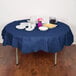 A table with a navy blue Creative Converting OctyRound table cover, plates, and food.