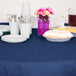 A table set with navy blue table cover, plates, and cups.