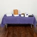 A purple Creative Converting table cover on a table with food.