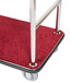 A rectangular stainless steel luggage cart with a red carpet on the platform.