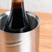 An American Metalcraft single bottle wine chiller on a table with a bottle of red wine inside.