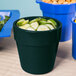 A green Tablecraft round condiment bowl with cucumbers and croutons.