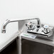 A Regency wall mount bar sink faucet above a sink.