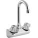 A silver Regency wall mount faucet with swivel gooseneck spout and knobs.