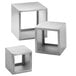 A group of silver metal cube risers with one on top.
