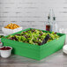 A Tablecraft green cast aluminum square bowl with salad in it.