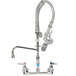 A chrome T&S wall mounted pre-rinse faucet with a hose and two faucets.