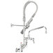A silver T&S EasyInstall wall mounted pre-rinse faucet with a chrome hose.