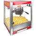 A Paragon 4 oz. commercial popcorn machine with popcorn in it in a red and white box.