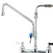 A chrome T&S deck mount pet grooming faucet with two handles and a hose.