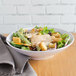 A bowl of salad with chicken and croutons in a Carlisle white melamine bowl.