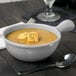 A Tablecraft natural cast aluminum soup bowl with a handle filled with soup and croutons.