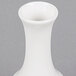 A white CAC porcelain bud vase with a hole in the bottom.