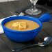 A Tablecraft cobalt blue cast aluminum soup bowl with a handle filled with soup and croutons.