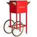 A red Carnival King cart for a PM470 popcorn machine with wheels and a handle.