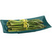 A Tablecraft hunter green cast aluminum flared rectangle platter with asparagus and lemon zest.