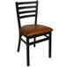A BFM Seating black steel side chair with a light brown vinyl seat.