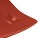 A red rectangular Tablecraft copper serving platter with a curved edge.