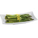 A natural cast aluminum flared rectangle platter with asparagus and lemon zest on it.