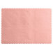 A dusty rose colored paper placemat with scalloped edges.