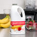 A white plastic jug of Torani Strawberry Banana Fruit Smoothie Mix with a red label.
