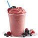 A pink Torani wildberry fruit smoothie with berries and ice cubes.