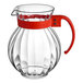 A clear plastic pitcher with a red handle.
