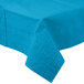 A turquoise blue tablecloth with a pattern on a table.