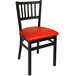 A BFM Seating black steel side chair with a red vinyl seat.