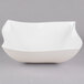 A white Fineline Wavetrends serving bowl with a curved edge on a gray surface.