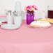 A table with a Classic Pink OctyRound table cover with plates and utensils on it.