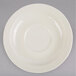 A white melamine saucer with a circular edge on a gray surface.