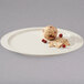 A round white melamine oval platter with a ball of food and crackers on it.