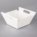 A white square porcelain bowl with handles.