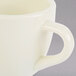 A close up of a white espresso cup with a handle.