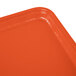 An orange Cambro rectangular tray on a table.
