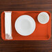 A rectangular orange pizzazz tray with a bowl and a cup and napkins on it.