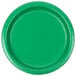 A close-up of a green Creative Converting paper plate with a white circle in the center.