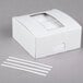 A white box with a window and white strips of paper.