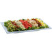 A Tablecraft gray rectangular cast aluminum serving platter with a salad topped with chicken, tomatoes, and lettuce.