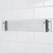 A stainless steel Edlund wall mounting bracket on a white wall.